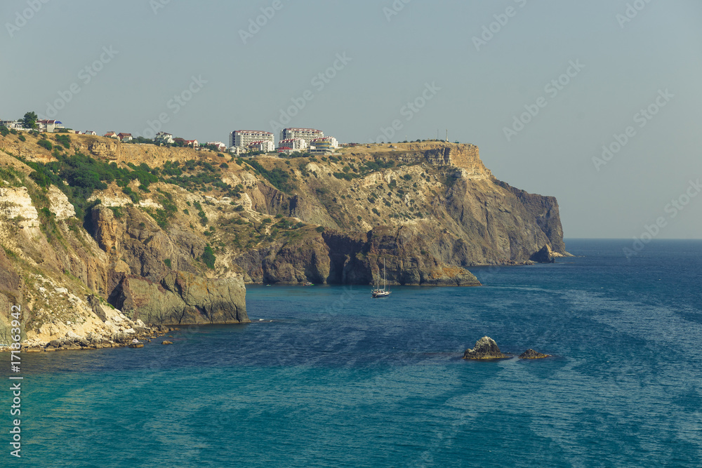 Cliff near the sea. The cape and the sea. Blue water. Sea surface. Patterns on the water. Summer day at the sea. Landscape. The postcard is sea. Black Sea.