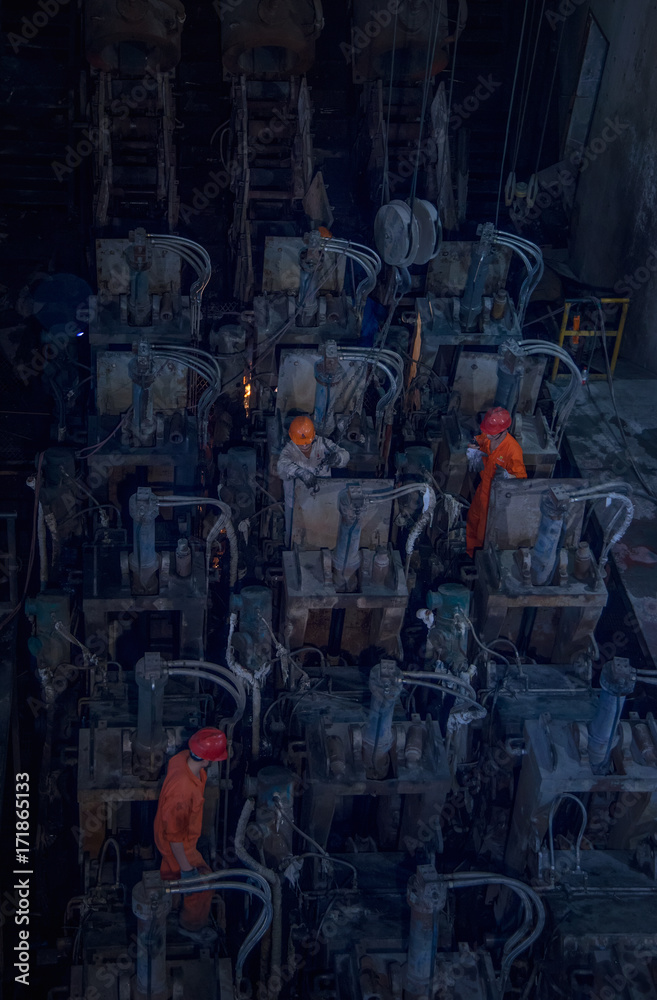 The workers are overhauling the electrodes in the steel plant