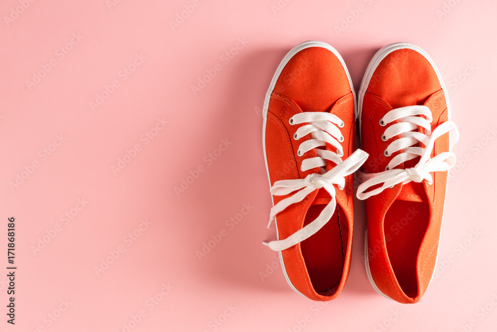 Classic red sneakers on a pale pink background
