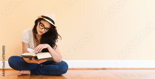 Young woman reading a book in a big room photo