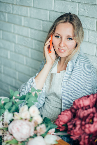 Smiling Mature Woman Florist Small Business Flower Shop Owner. She is using her telephone to take orders for her store photo
