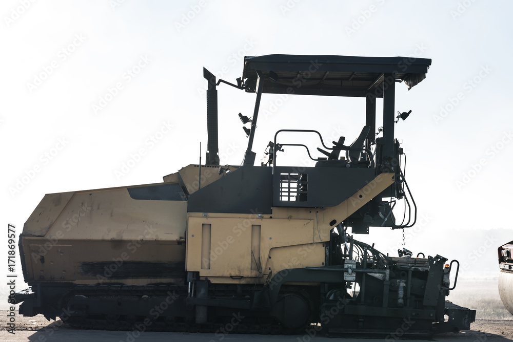 Image of asphalt spreader machine with yellow color,