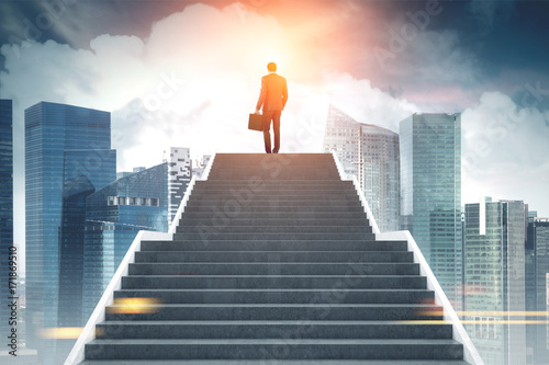 Businessman climbing stairs, morning city