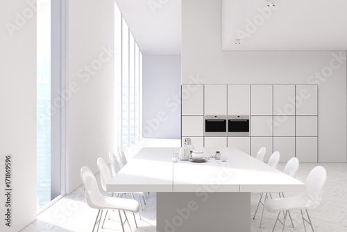 White kitchen with a table, ovens close up © ImageFlow