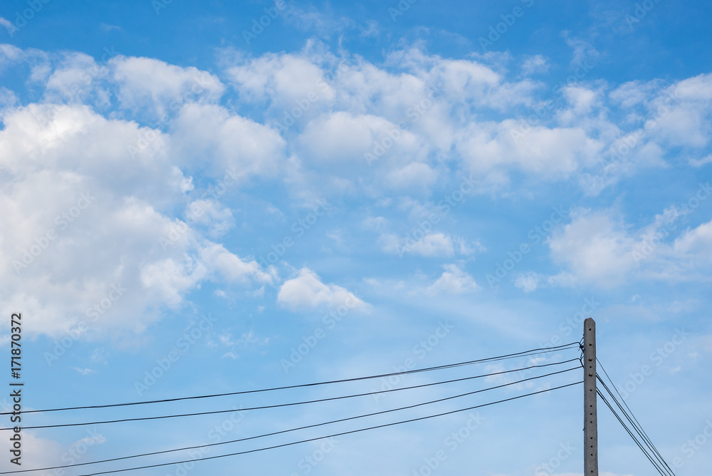 Fluffy soft white clouds with blue sky in day time light and electric pole in bottom. Fluffy soft white clouds with blue sky in day time light and electric pole in bottom.