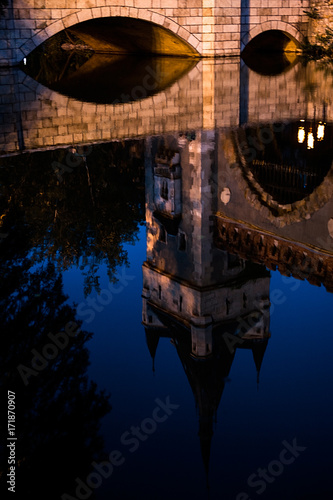 evening picture with castle tower and bridge reflected in the lake photo