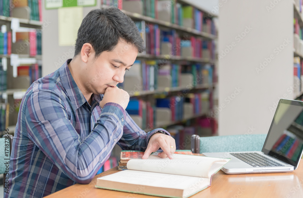 young student reading book at library. young student reading book at library.
