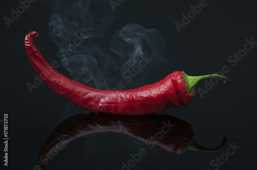 Smoking Hot Red Jalapeno Pepper isolated on a pure black background.