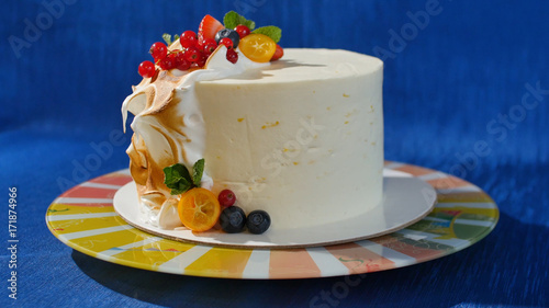 Traditional Christmas fruit cake with white frosting and sugared fruits. Cream cake with kumquat, cranberries, strawberries
