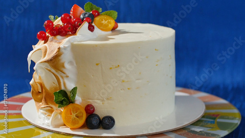 Traditional Christmas fruit cake with white frosting and sugared fruits. Cream cake with kumquat, cranberries, strawberries