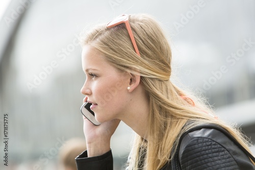 Blonde, attractive and young woman speaking on mobile telephone