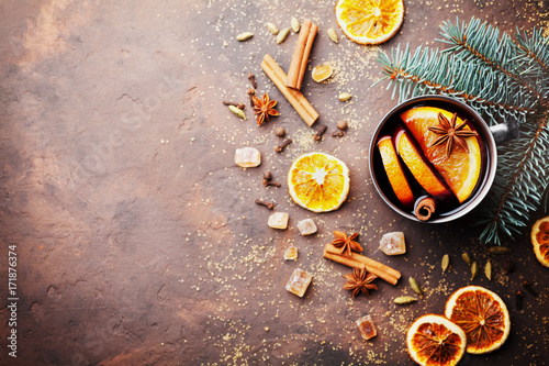 Christmas mulled wine or gluhwein with spices and orange slices on rustic table top view. Traditional drink on winter holiday. Copy space for recipe.