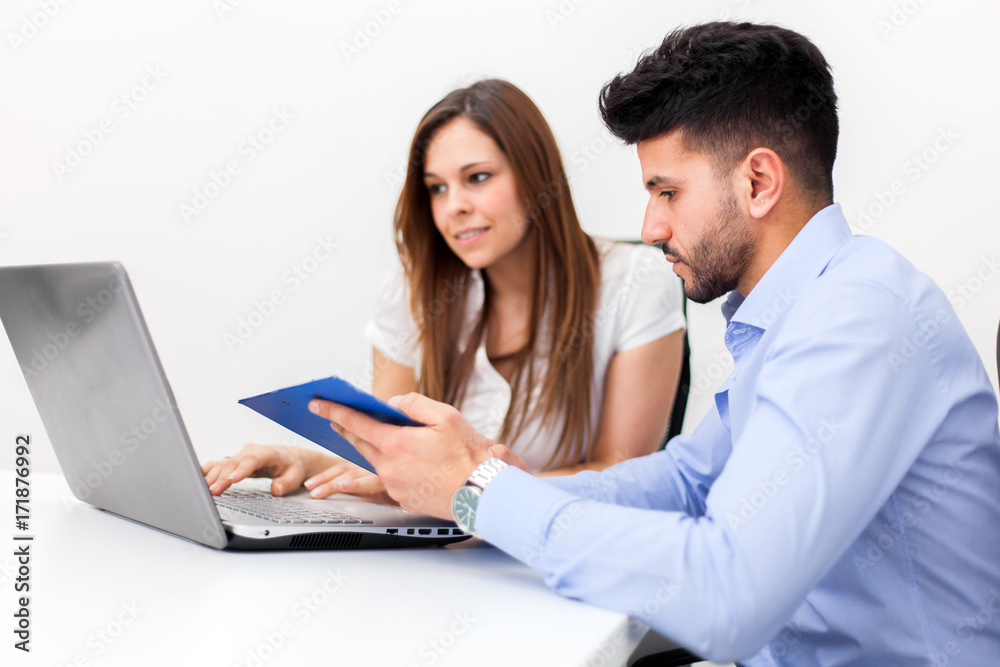 Smiling couple of business people using a laptop computer Smiling couple of business people using a laptop computer