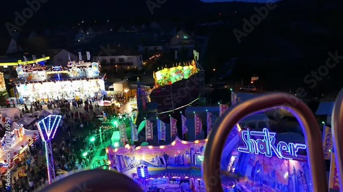 Blick vom Riesenrad auf einen bunt beleuchteten Festplatz.  photo