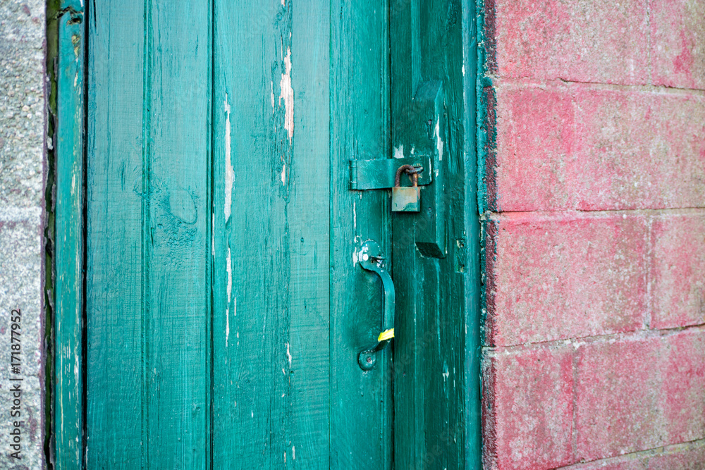 locked green door in a red cinder block facade locked green door in a red cinder block facade