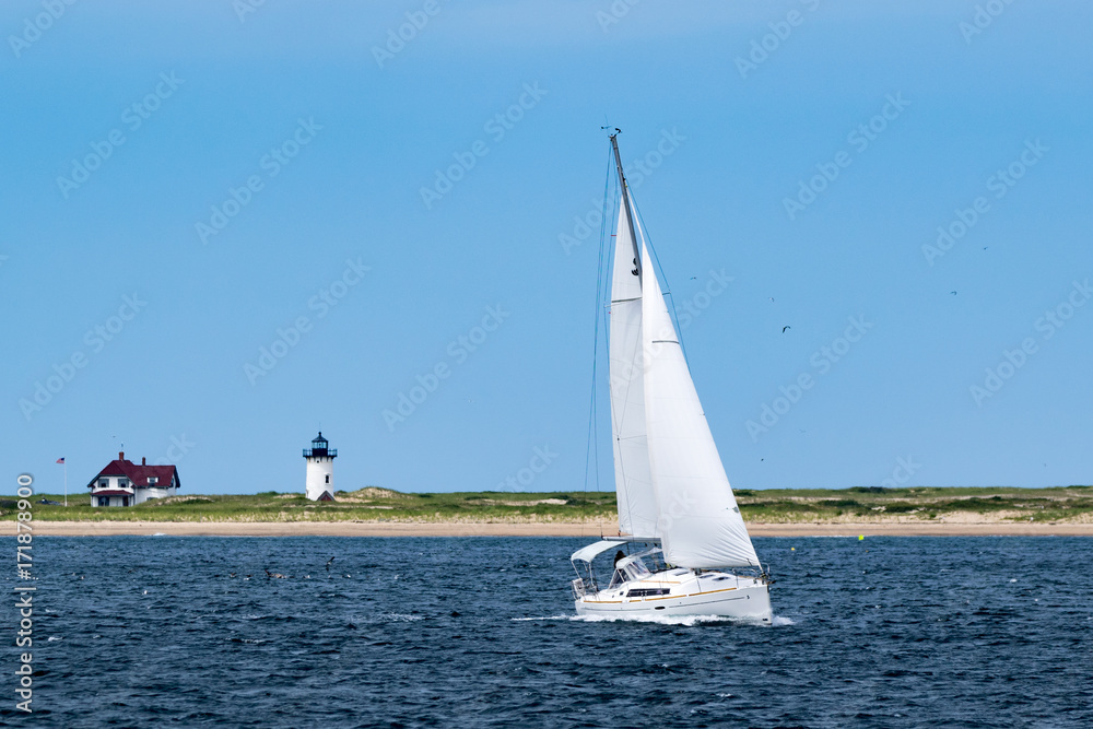 Fototapeta premium Sailboat with Lighthouse in the background