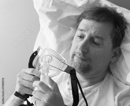 Man considers a CPAP mask photo