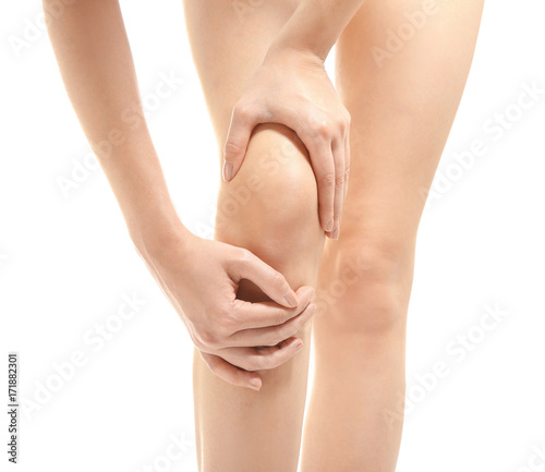 Young woman suffering from leg pain on white background