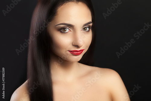 Healthy Hair. A beautiful model for a woman with long shiny hair. Portrait of a beautiful brunette girl with a natural makeup  a beautiful face  a beautiful brown color for hair and curls. Makeup.