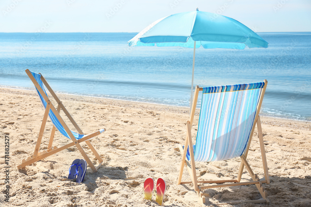 Beach chairs and umbrella on sea coast Beach chairs and umbrella on sea coast