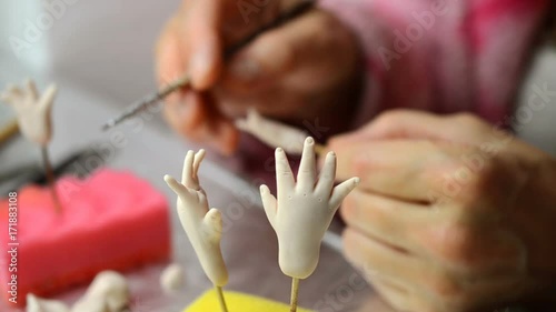 The master artist processes for doll's billet. Making and rocessing of hands and fingers.  Selective focus in the foreground. photo