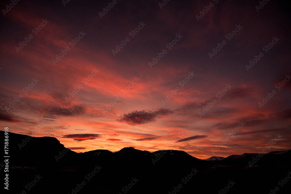 Landscape travel of a nature of a sunset sunrise with clouds in the mountains of Spitsbergen Svalbard near the Norwegian city Longyearbyen