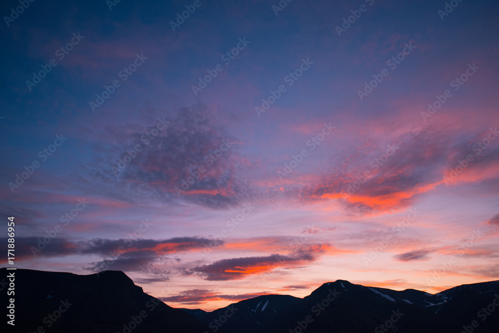 Landscape travel of a nature of a sunset sunrise with clouds in the mountains of Spitsbergen Svalbard near the Norwegian city Longyearbyen