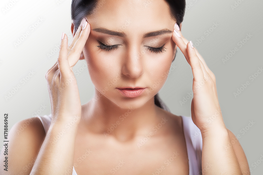 Pain. A beautiful woman on a gray background, stress and headache with migraine headaches, she wrestled with pain, a big portrait, high quality, professional makeup. Pain. A beautiful woman on a gray background, stress and headache with migraine headaches, she wrestled with pain, a big portrait, high quality, professional makeup.