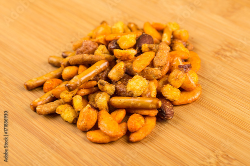 Pile of spiced crunch snack mix on a wood background