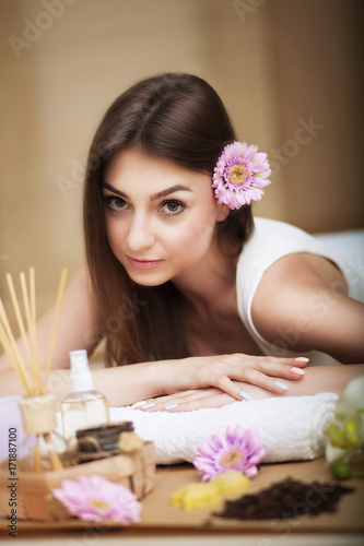 Spa treatments. Beautiful young girl lying on a massage table. Aroma oil.Clean and well-groomed skin. Beautiful smile. Conception of beauty and health.