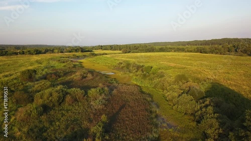 Aerial View. Flying over the beautiful sunny field with river
