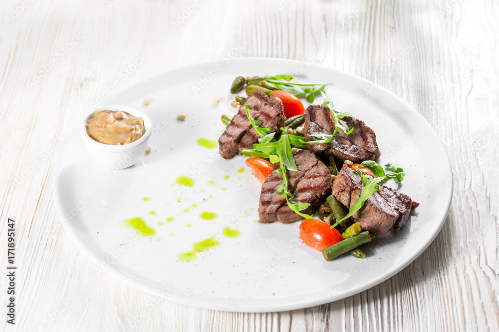 Grilled steak delicious beef meat on a white plate on a light background menu Grilled steak delicious beef meat on a white plate on a light background menu
