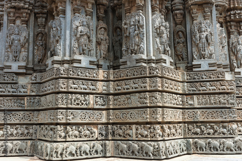 Mysore, India - October 27, 2013: Stone corner friezes with deity statues on outside wall of central shrine, called Trikuta, at Chennakesave temple in Somanathpur.  © Klodien
