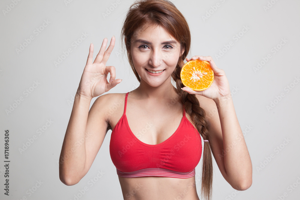 Beautiful Asian healthy girl show OK with orange fruit. Beautiful Asian healthy girl show OK with orange fruit.