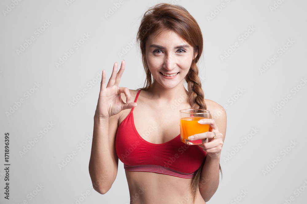 Beautiful Asian healthy girl drinking orange juice show OK sign. Beautiful Asian healthy girl drinking orange juice show OK sign.