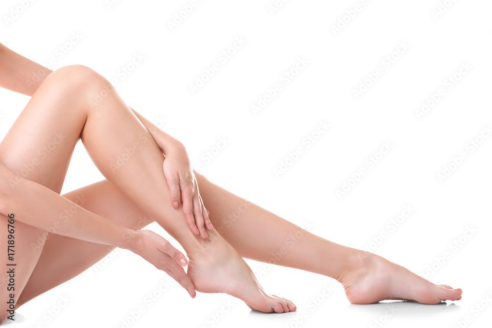 Young woman touching her leg on white background Young woman touching her leg on white background