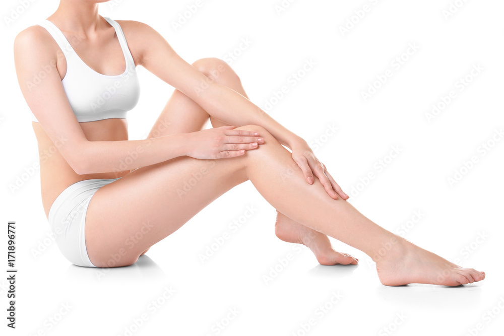 Young woman touching her leg on white background Young woman touching her leg on white background