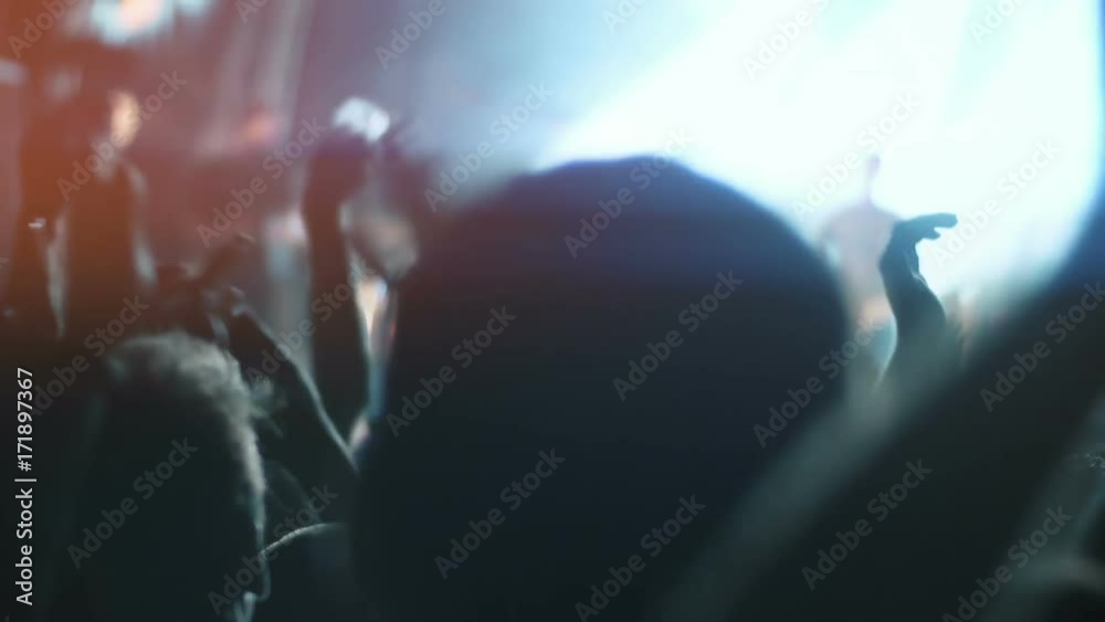 Night rock concert front row crowd cheering hands in air.HD Series of real time close up shots from a night rock concert.People cheer and clap their hands in unison against the strobing stage lights.