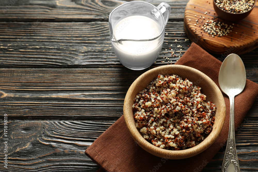 Bowl with boiled quinoa grains on wooden table Bowl with boiled quinoa grains on wooden table
