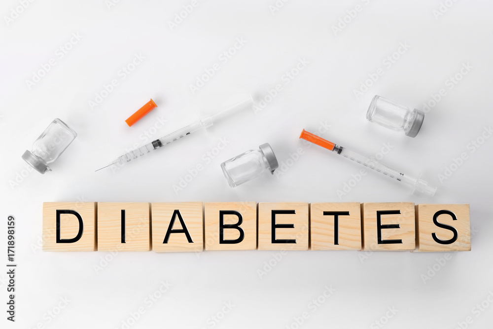 Composition with word Diabetes and syringes on light background