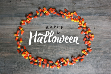 Happy Halloween Calligraphy With Candy Corn Oval Border Over Rustic Wooden Background, Horizontal