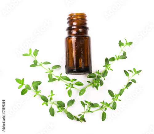 Bottle of essential oil with herbs thyme isolated on white background