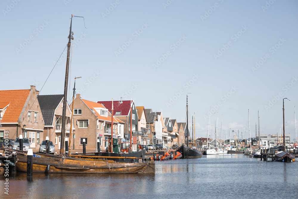 Sail boats and motor boats docked in a harbor in the historic fishing village of Urk in the Netherlands