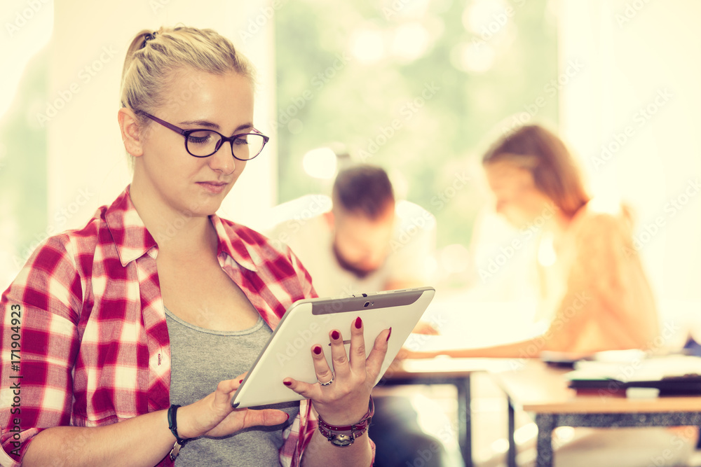 Student girl with tablet in front of her classmates