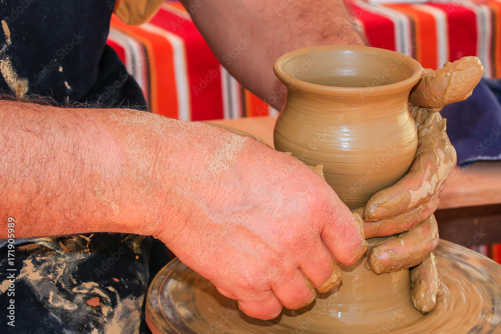 Hands of potter man making a jar