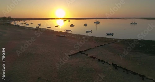Sunrise aerial seascape, in Ria Formosa wetlands natural park, shot over Cavacos beach. Algarve.