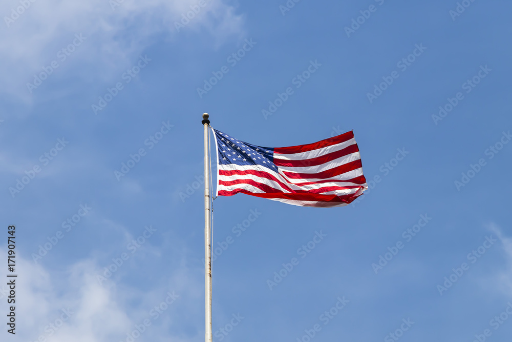 United States of America flag with cloudy blue sky