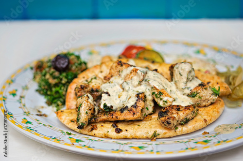 Lebanese Chicken taouk. Grilled marinated chicken fillet, hummus, babe ganoush, fattoush olives & pita  photo