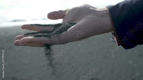 Hands with black sand at the iceland Beach. photo