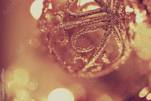 Christmas background. Christmas lace ball on a blurry light brown warm background. 